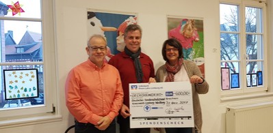 Erfreut nimmt Karsten Schmidt (Vorsitzender des DKSB) den Spendenscheck von Gerhard Stillger, und Tania Rohletter entgegen.